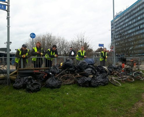 volunteer team by Ashford International Station with bags of rubbish and bicycles collected