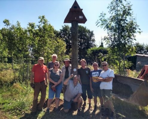 volunteer group in front of barn owl box.